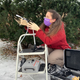 Elizabeth Clare, a scientist, kneels while holding a filter for sampling air for environmental DNA.